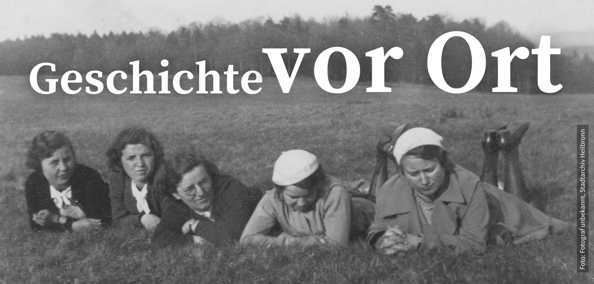 Header Startseite Waldheide - Damen liegen im Gras - Text "Geschichte vor Ort"